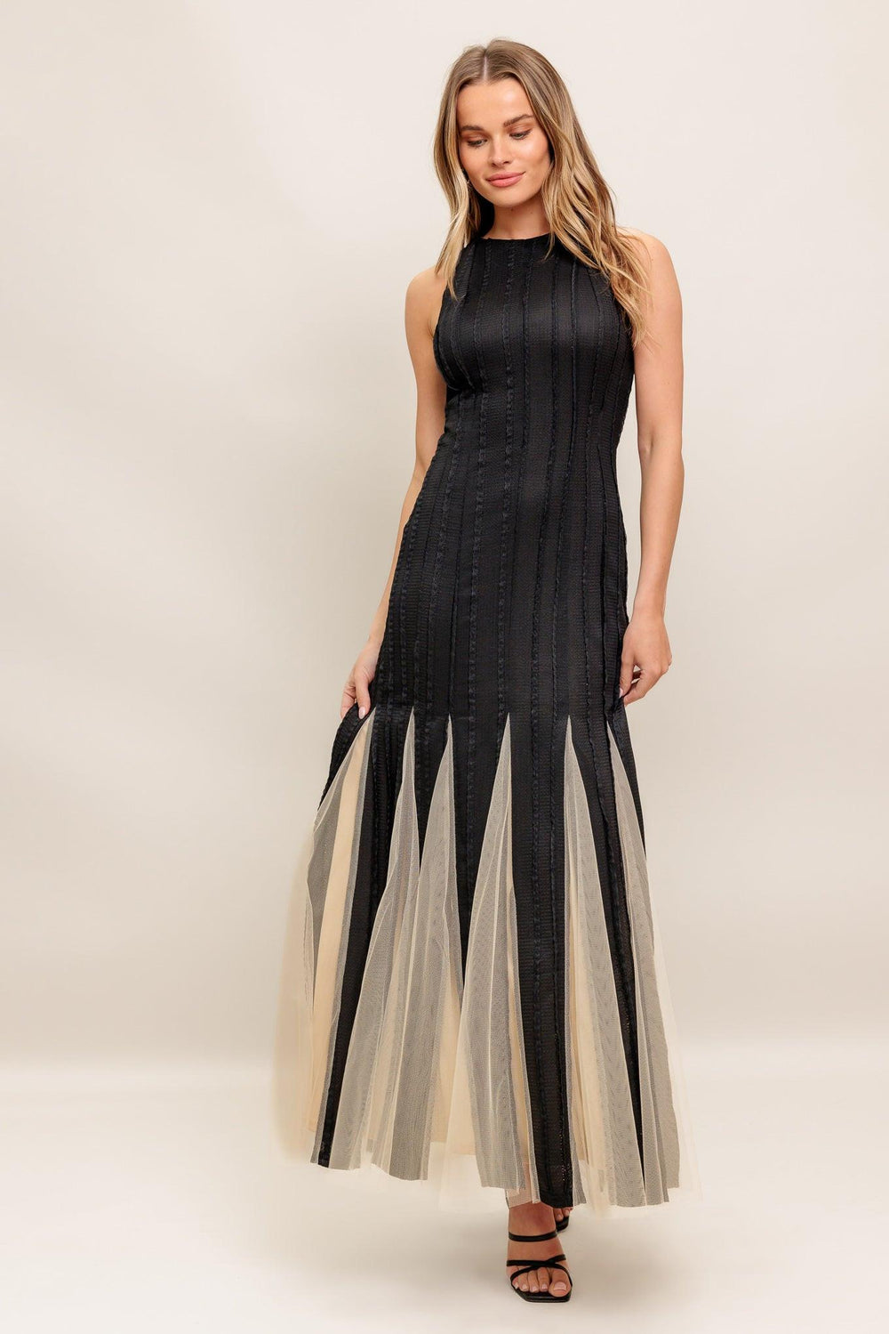 A solid knit maxi dress featuring round neckline, sleeveless, tulle inset bottom and back zipper closure