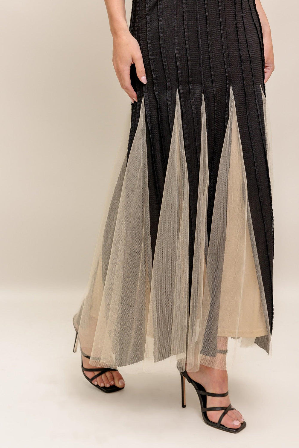 A solid knit maxi dress featuring round neckline, sleeveless, tulle inset bottom and back zipper closure