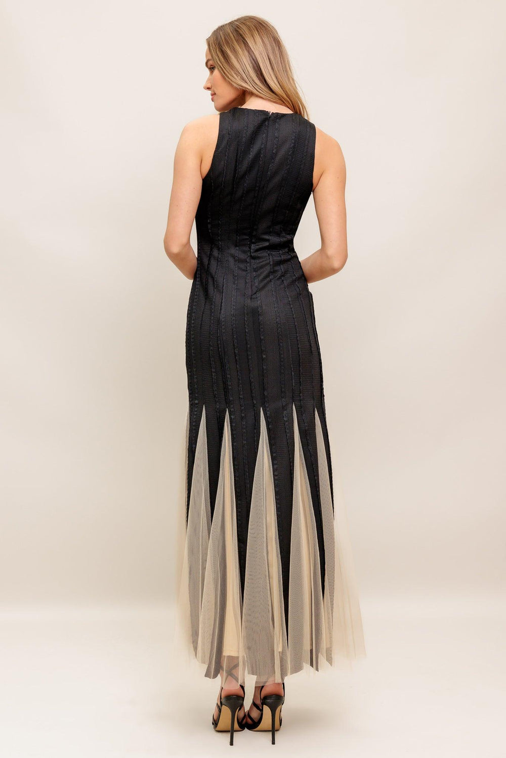 A solid knit maxi dress featuring round neckline, sleeveless, tulle inset bottom and back zipper closure