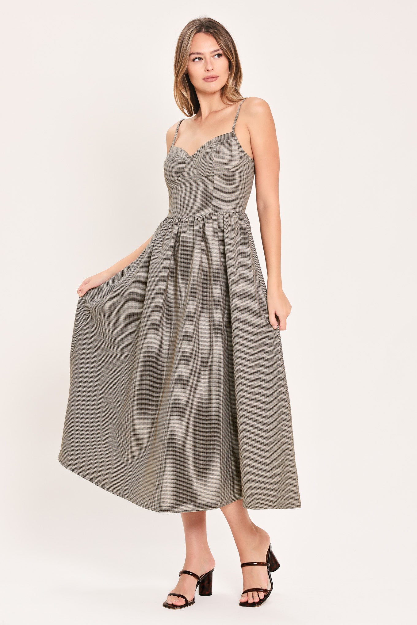 A woman wearing a plaid taupe and brown spaghetti strap midi dress | Flying Tomato