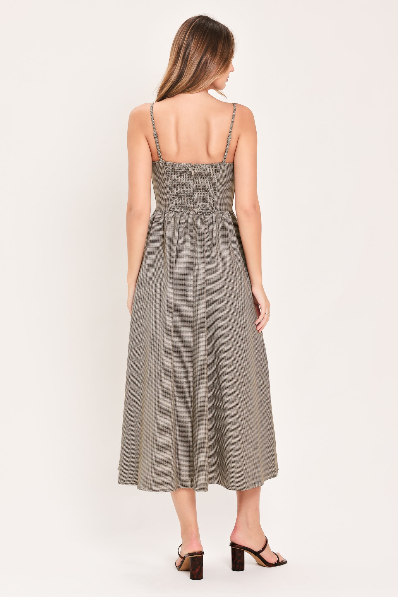 A woman wearing a plaid taupe and brown spaghetti strap midi dress | Flying Tomato