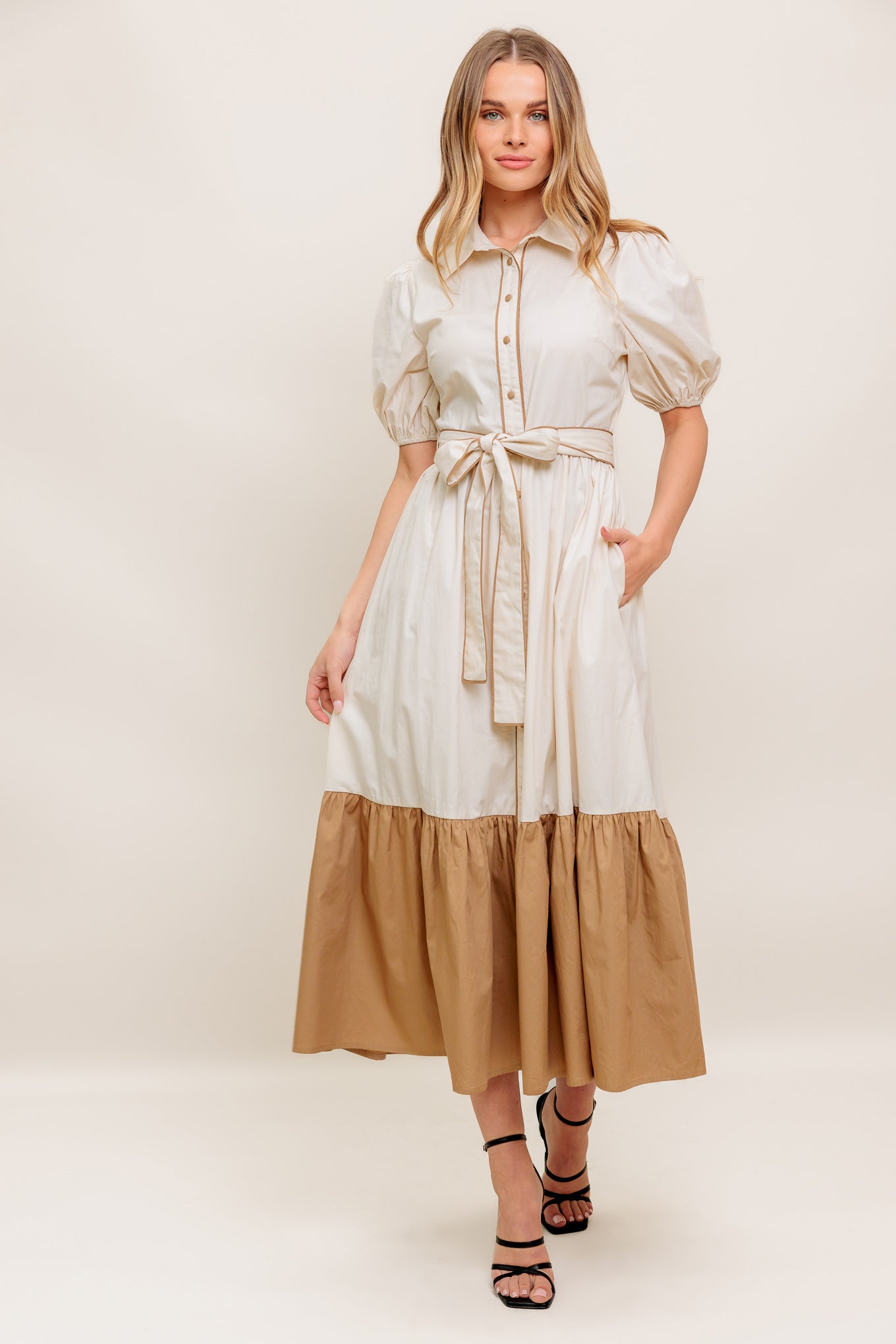A solid color blocked midi dress featuring collar, short puff sleeve, button down, self sash tie and ruffled hemline