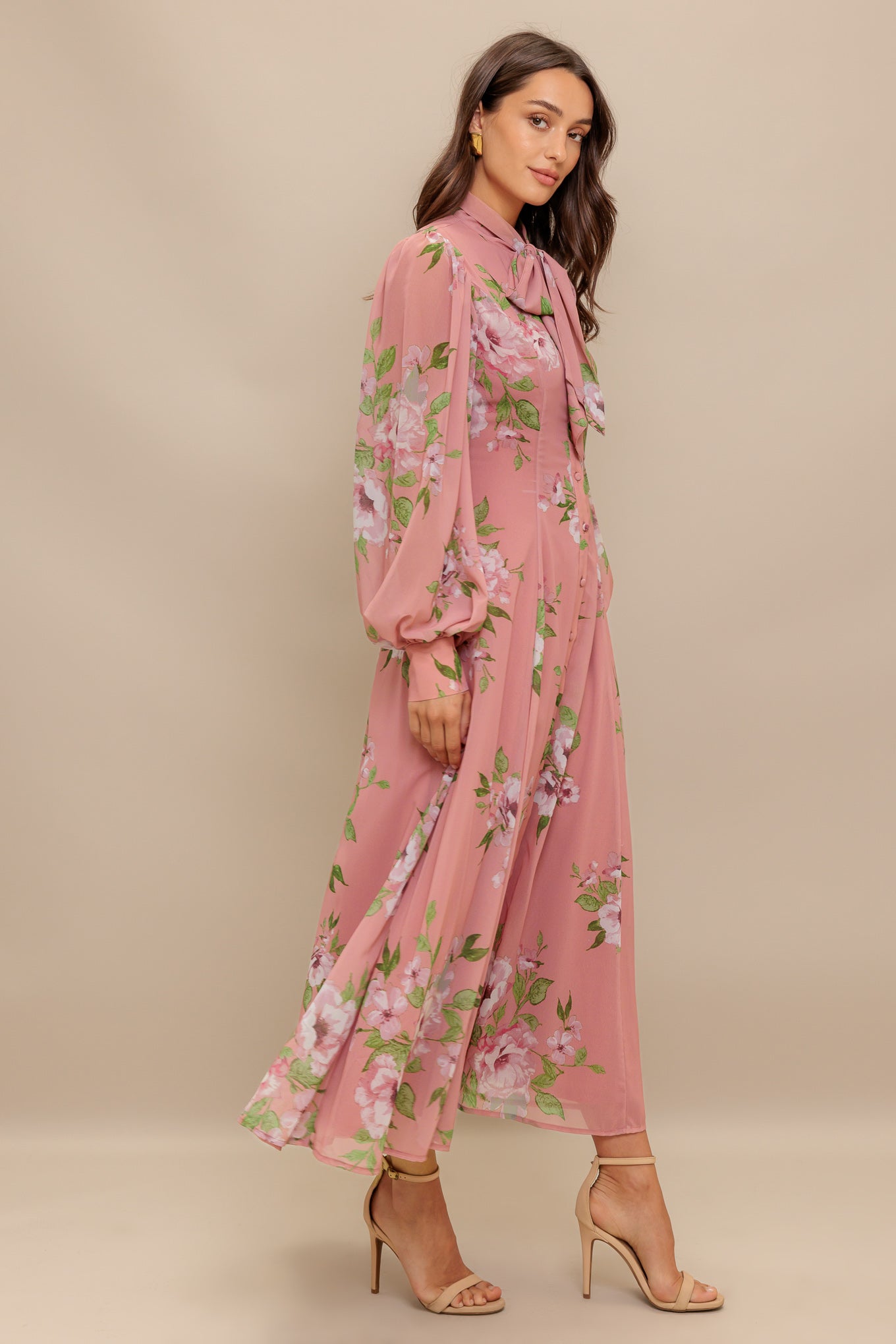 A printed woven midi dress featuring high neckline with bow tie, short puff sleeve with cuff, front button down and circle skirt