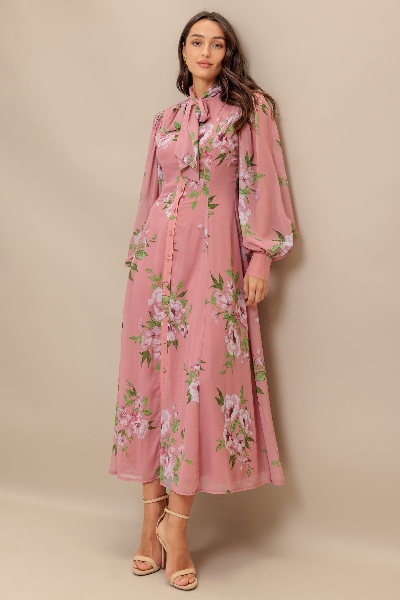 A printed woven midi dress featuring high neckline with bow tie, short puff sleeve with cuff, front button down and circle skirt