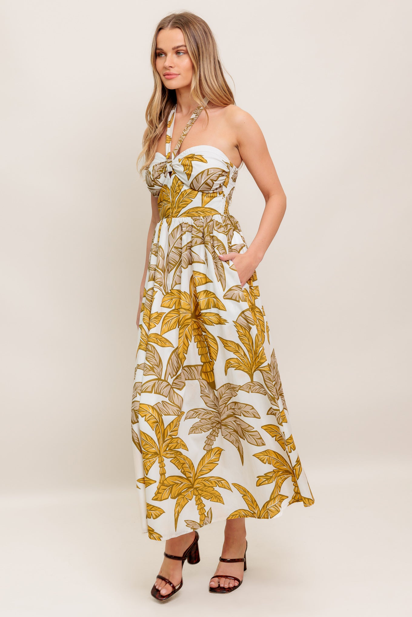 A printed woven midi dress featuring halter neckline with back neck tie, full skirt and smocked back bodice