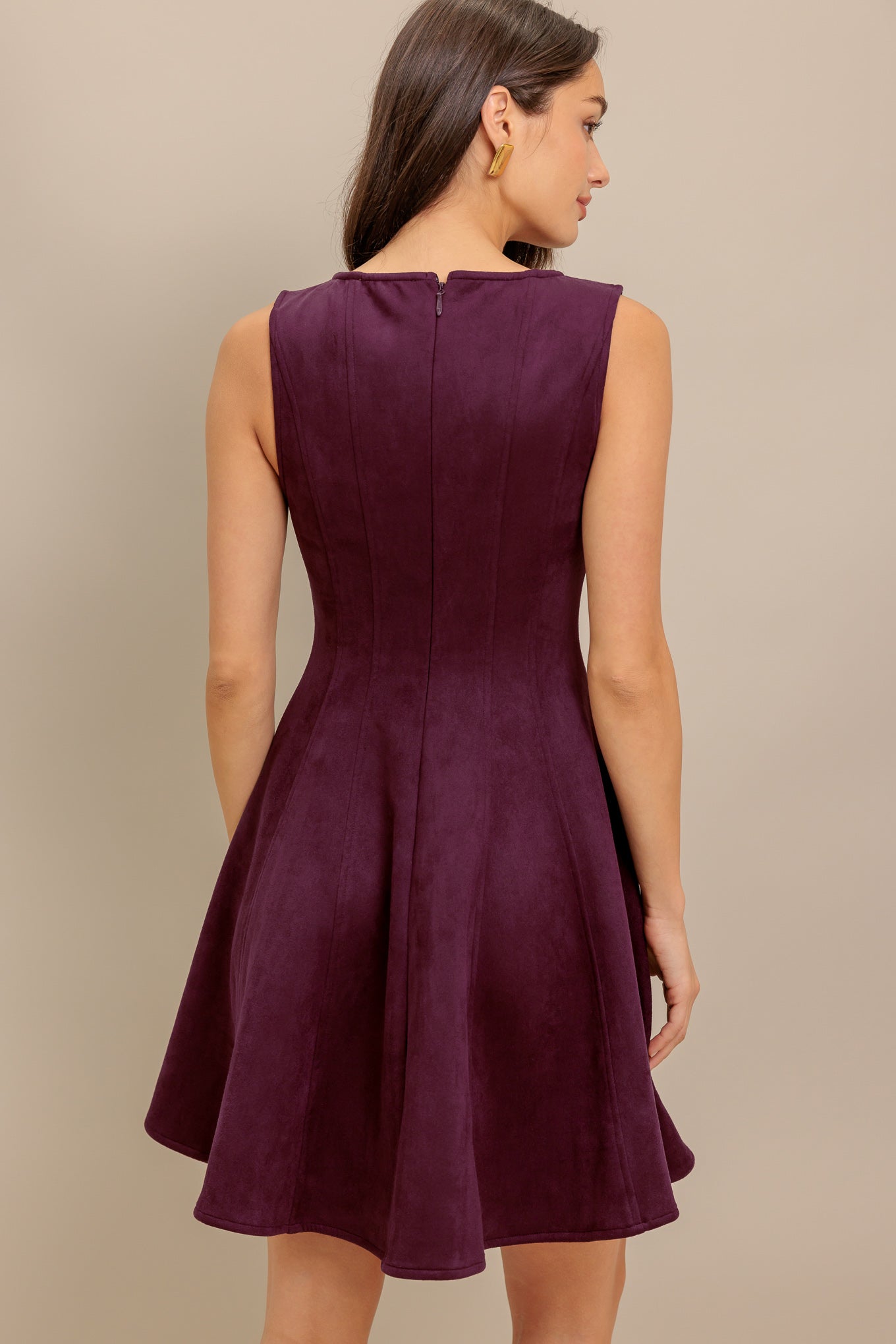 A solid faux suede mini dress featuring round neckline, sleeveless, circle skirt and back zipper closure