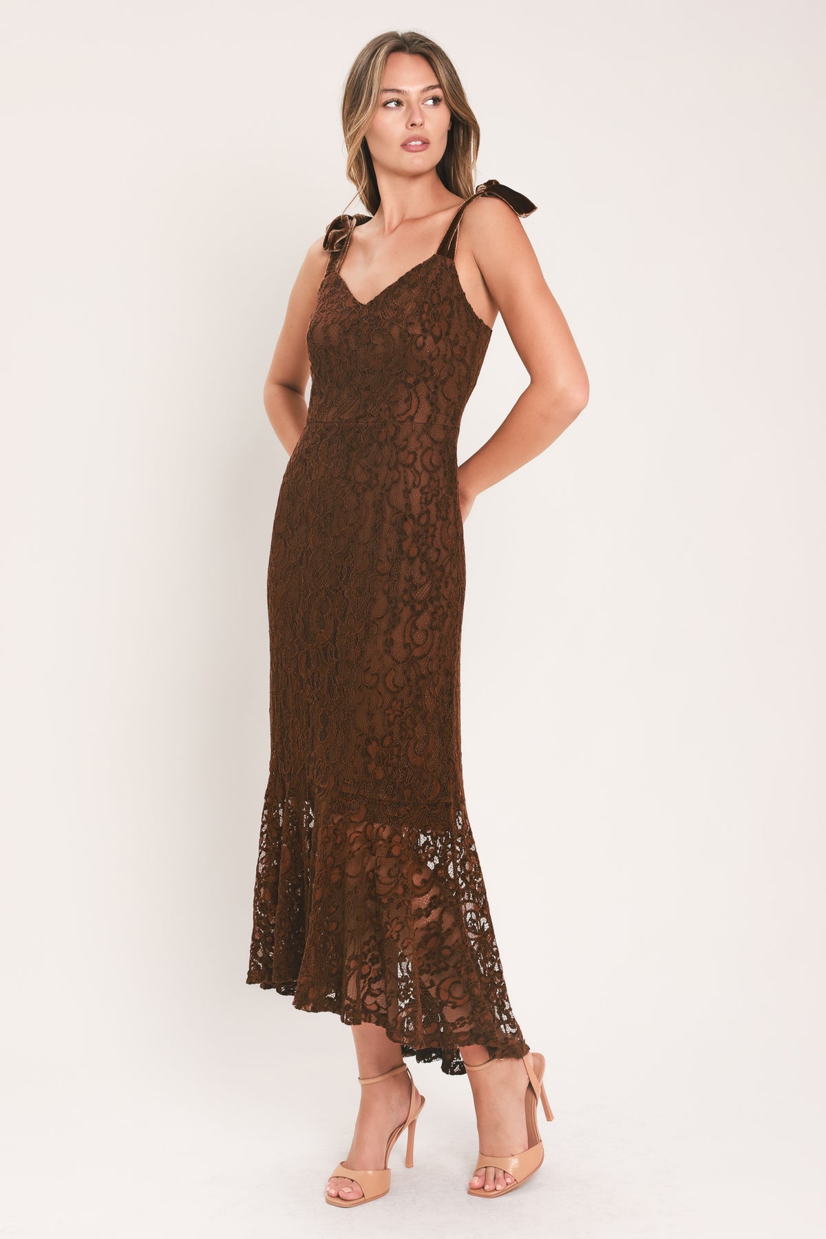 A woman modeling a sleeveless brown lace midi dress with shoulder tie details and a flared lace hem | Flying Tomato