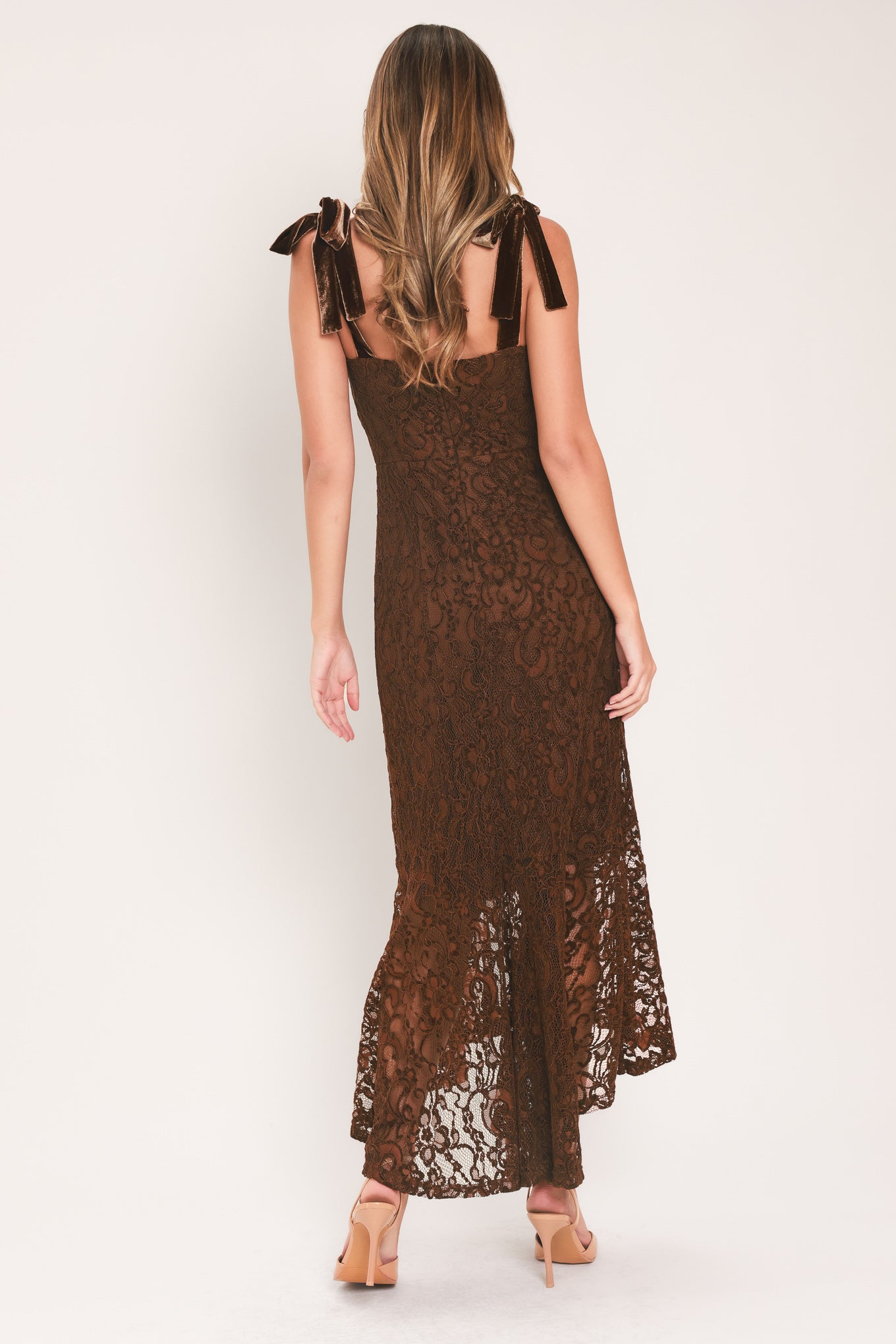 A woman modeling a sleeveless brown lace midi dress with shoulder tie details and a flared lace hem | Flying Tomato