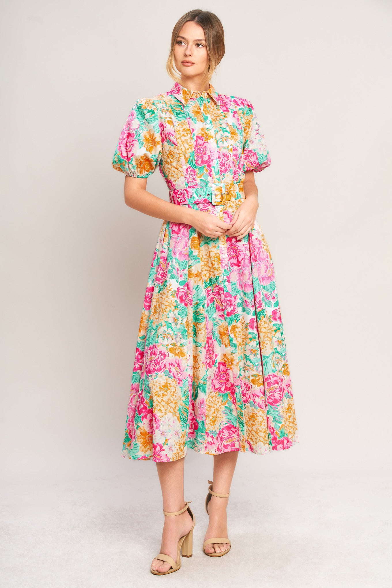Woman wearing a colorful floral dress on a white background