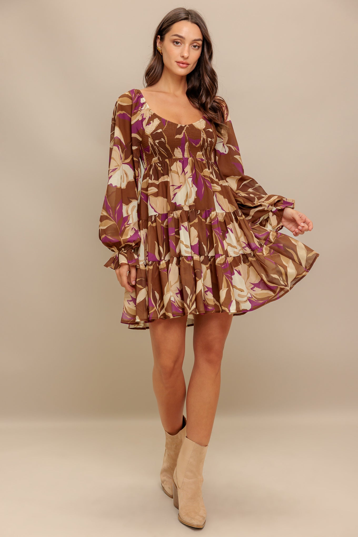 A printed woven mini dress featuring U neckline, long sleeve with ruffled cuff, smocked bodice and tiered skirt