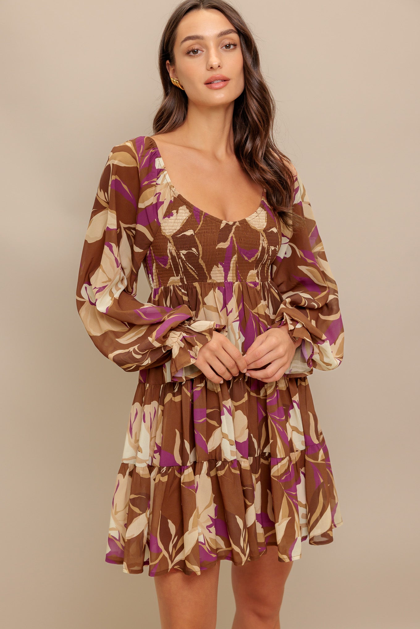 A printed woven mini dress featuring U neckline, long sleeve with ruffled cuff, smocked bodice and tiered skirt