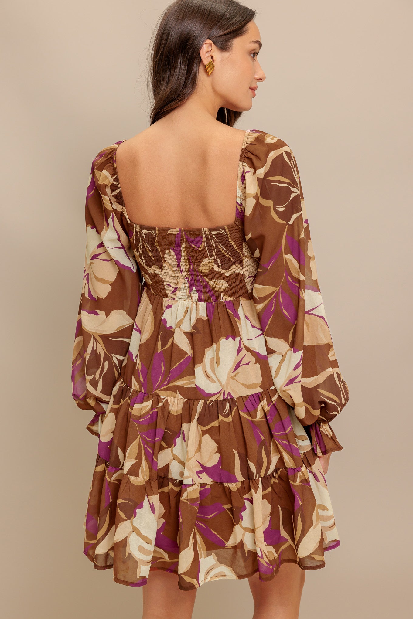 A printed woven mini dress featuring U neckline, long sleeve with ruffled cuff, smocked bodice and tiered skirt