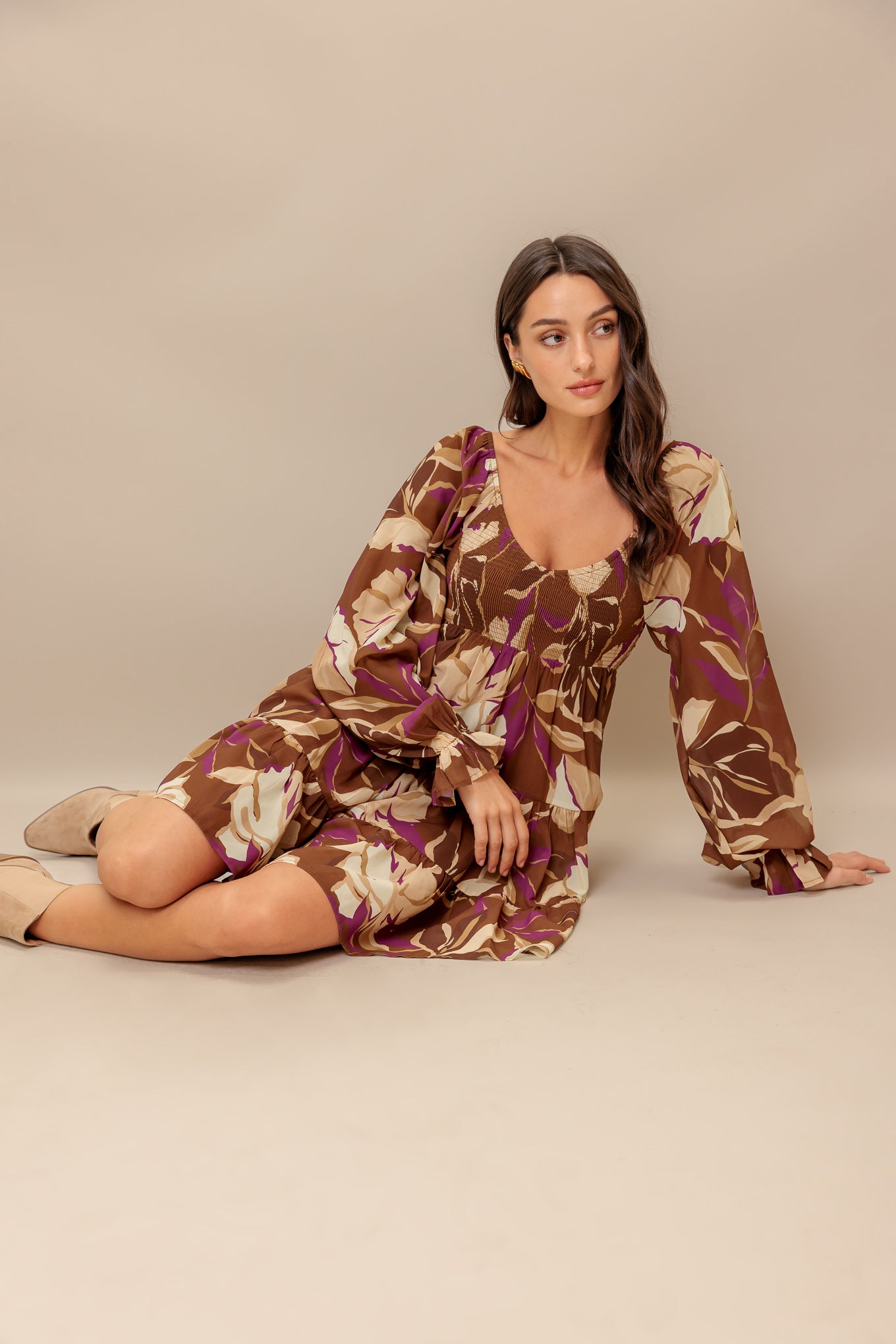 A printed woven mini dress featuring U neckline, long sleeve with ruffled cuff, smocked bodice and tiered skirt