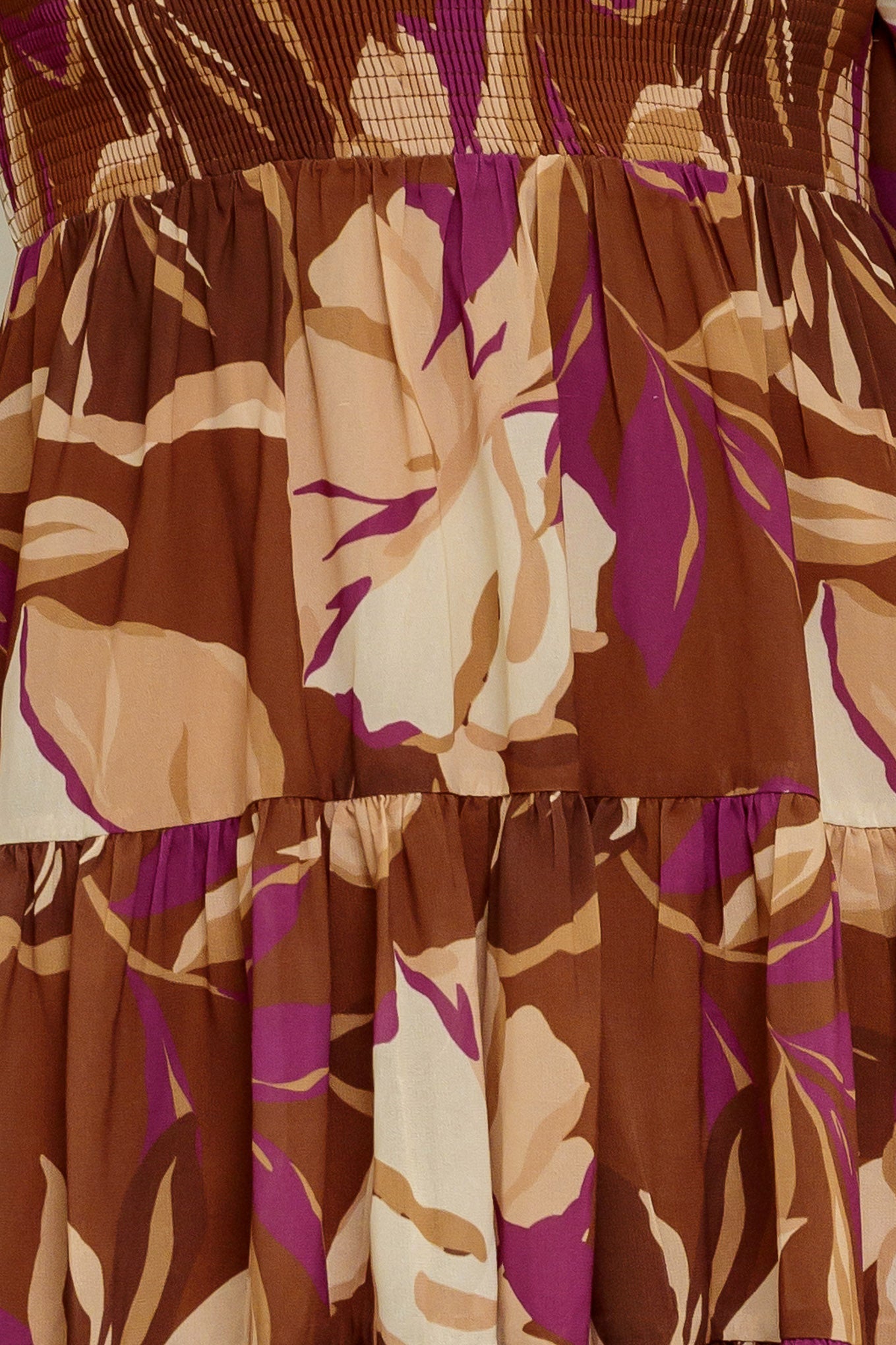 A printed woven mini dress featuring U neckline, long sleeve with ruffled cuff, smocked bodice and tiered skirt