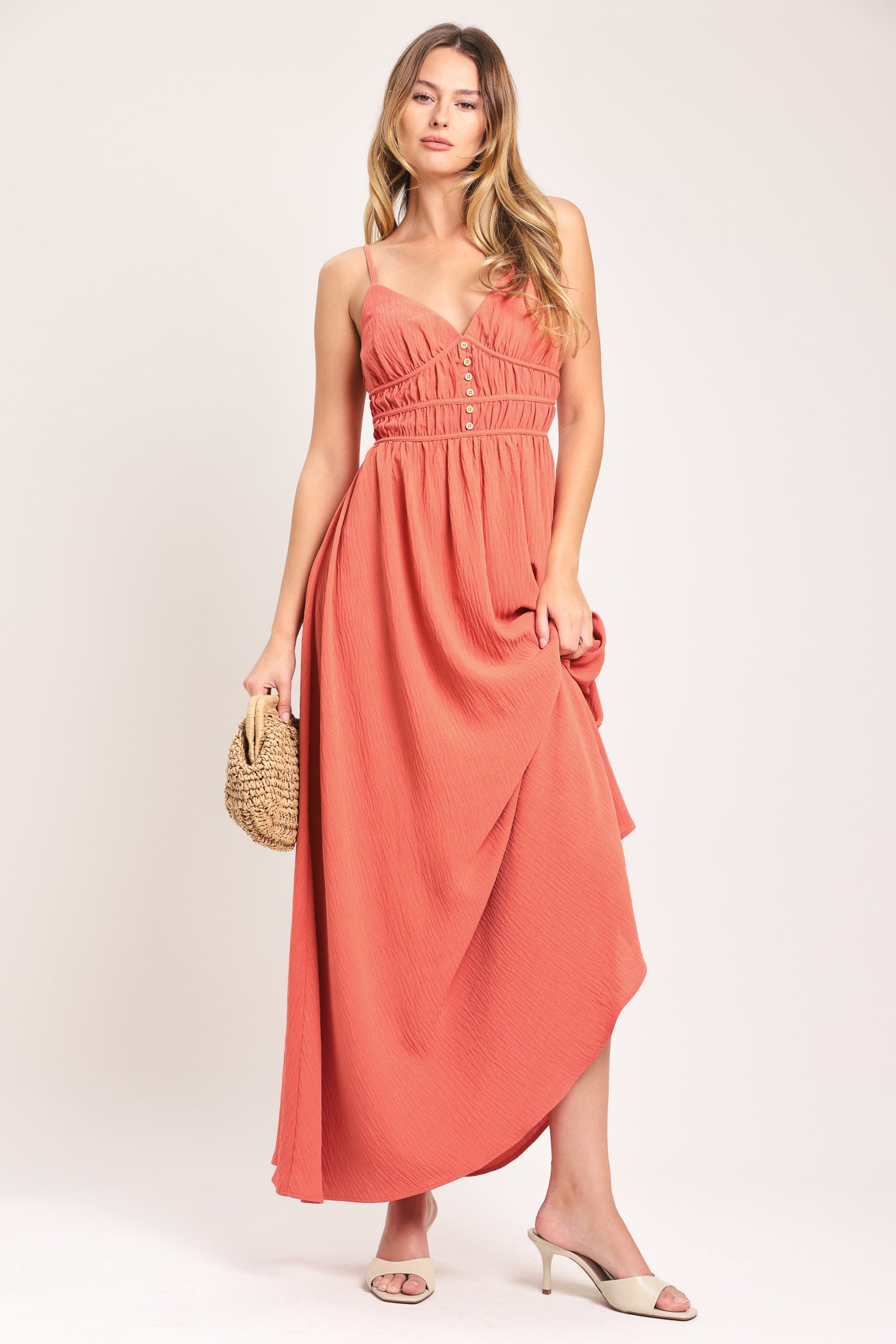 Woman wearing a coral maxi dress featuring cami top, waist yoke with shirring and button, elastic waist and smocked back bodice | Flying Tomato