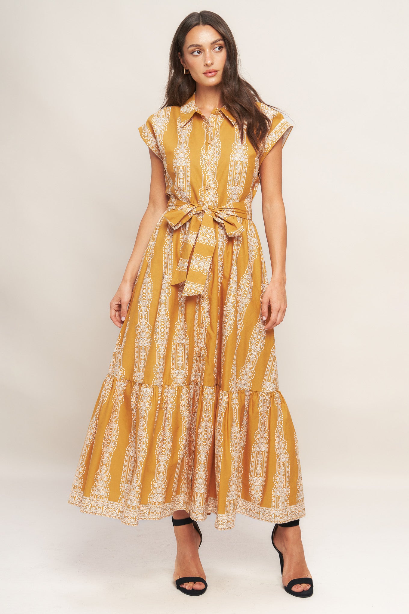 A printed woven midi dress featuring collar, button down, short sleeve, self sash tie and ruffled hemline
