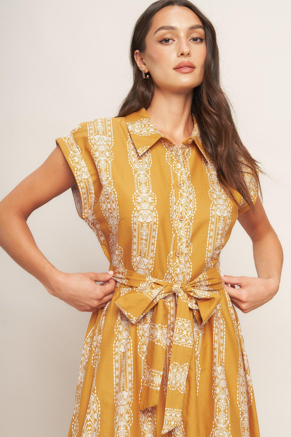 A printed woven midi dress featuring collar, button down, short sleeve, self sash tie and ruffled hemline
