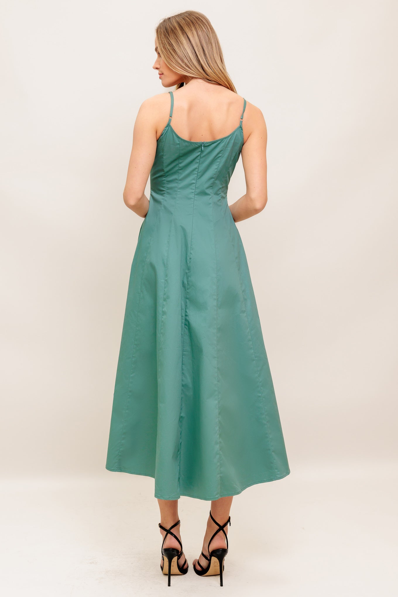 A solid woven midi dress featuring curved neckline, sleeveless, straps, circle skirt and back zipper closure