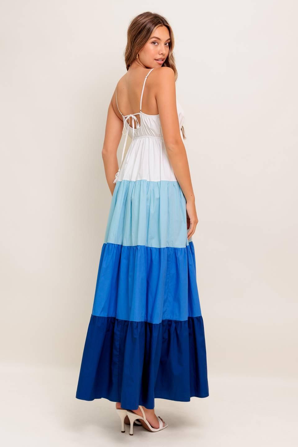 A color blocked woven maxi dress featuring cami top with straps, tiered skirt and back tie closure