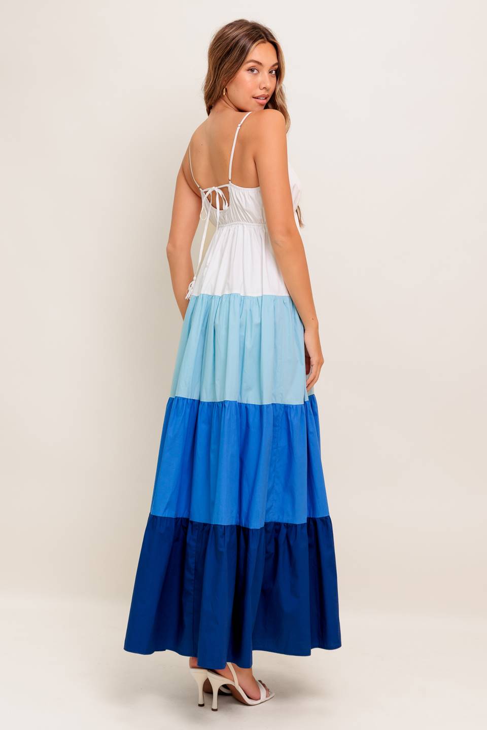 A color blocked woven maxi dress featuring cami top with straps, tiered skirt and back tie closure