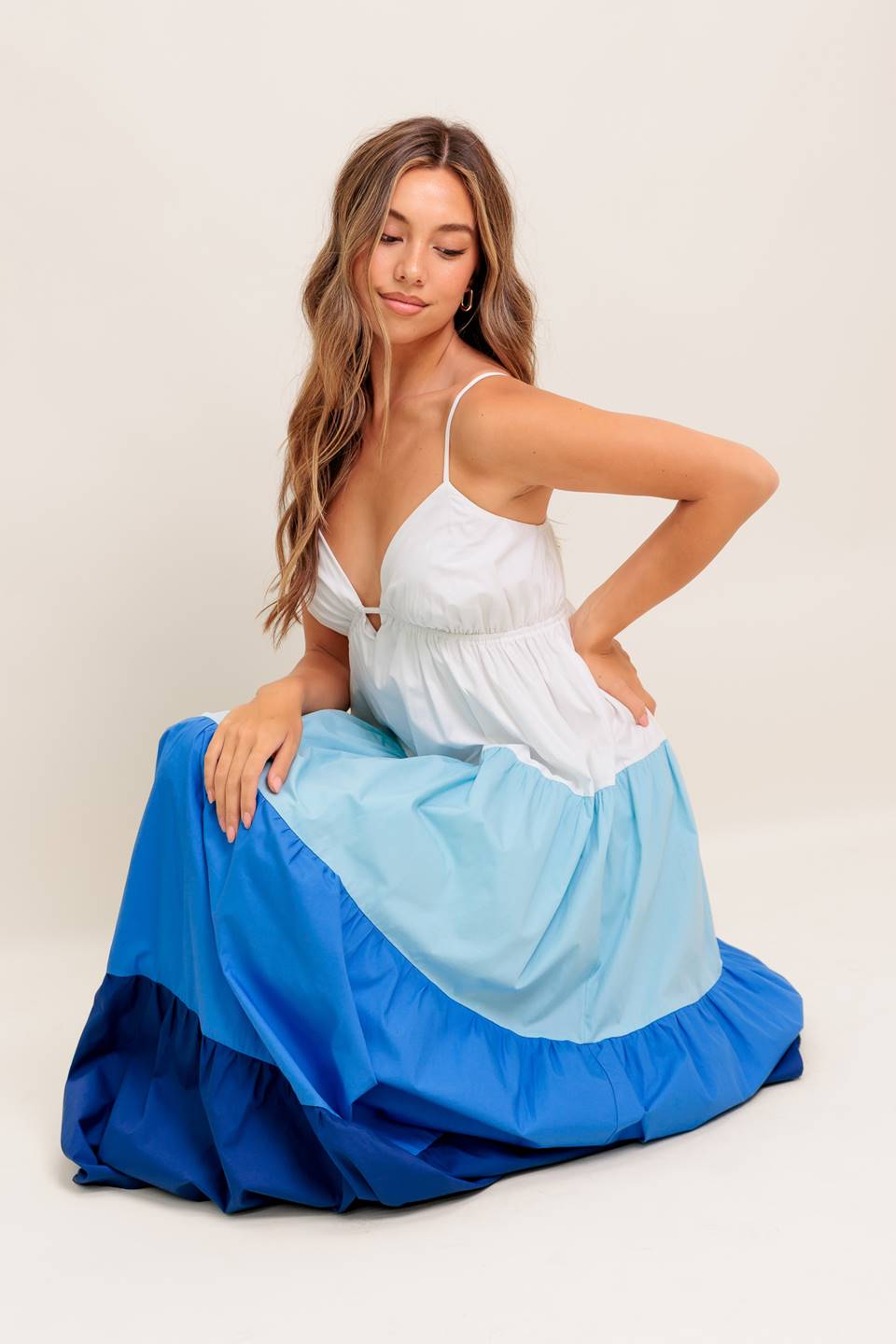 A color blocked woven maxi dress featuring cami top with straps, tiered skirt and back tie closure