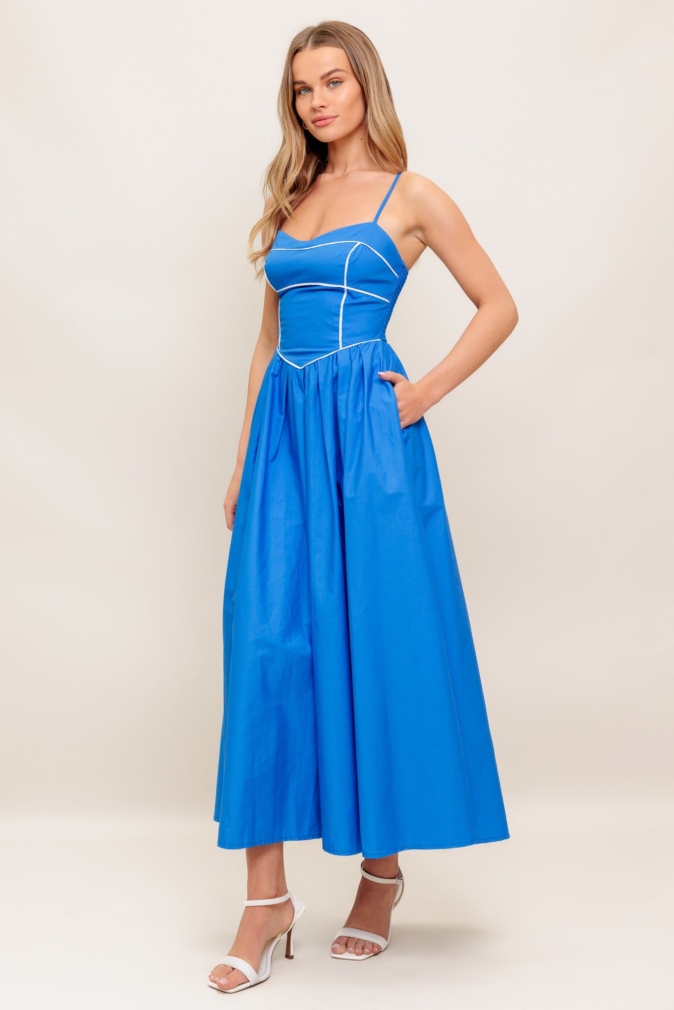 A solid woven midi dress featuring sweetheart neckline, straps, basque waist, full skirt and smocked back bodice