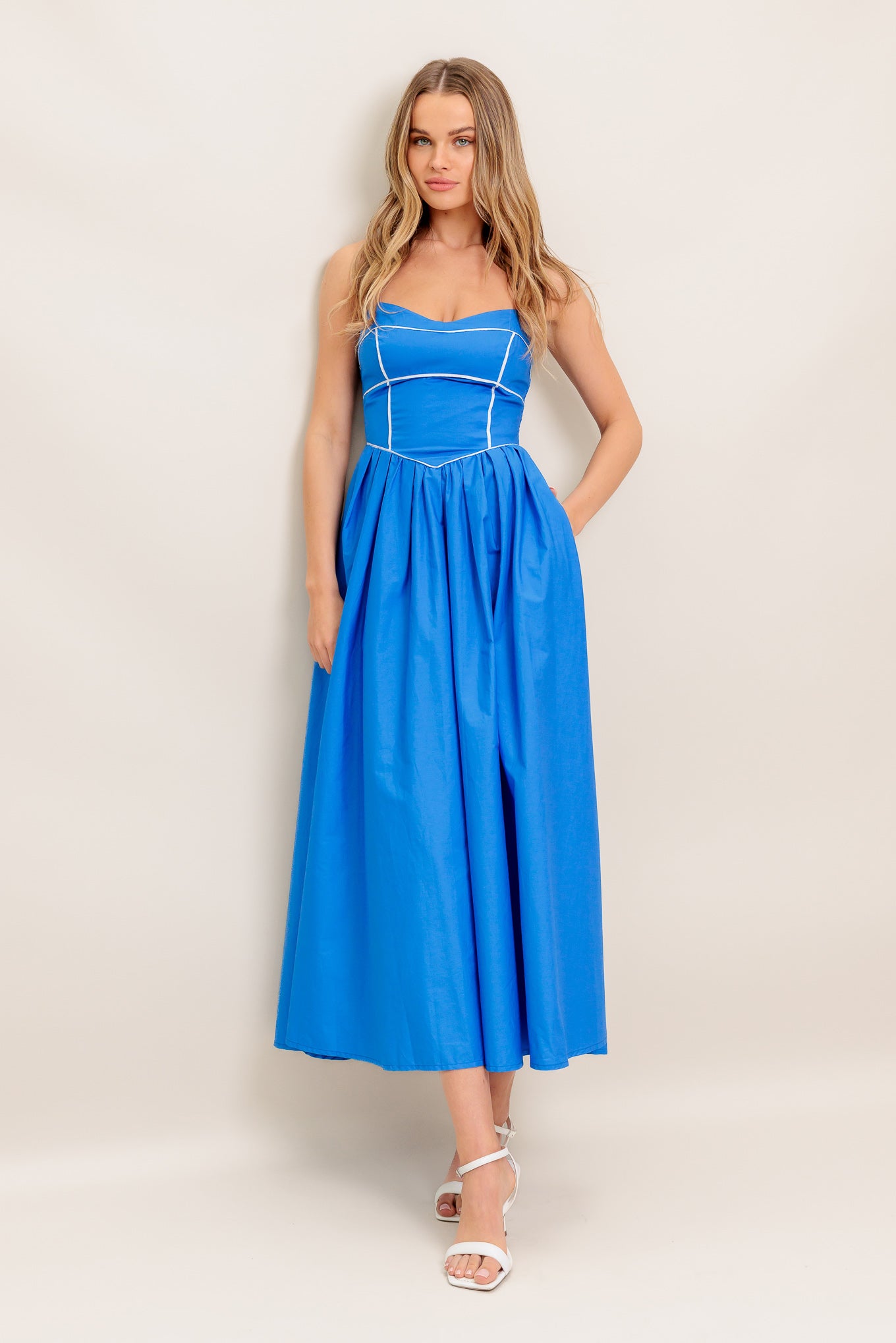 A solid woven midi dress featuring sweetheart neckline, straps, basque waist, full skirt and smocked back bodice