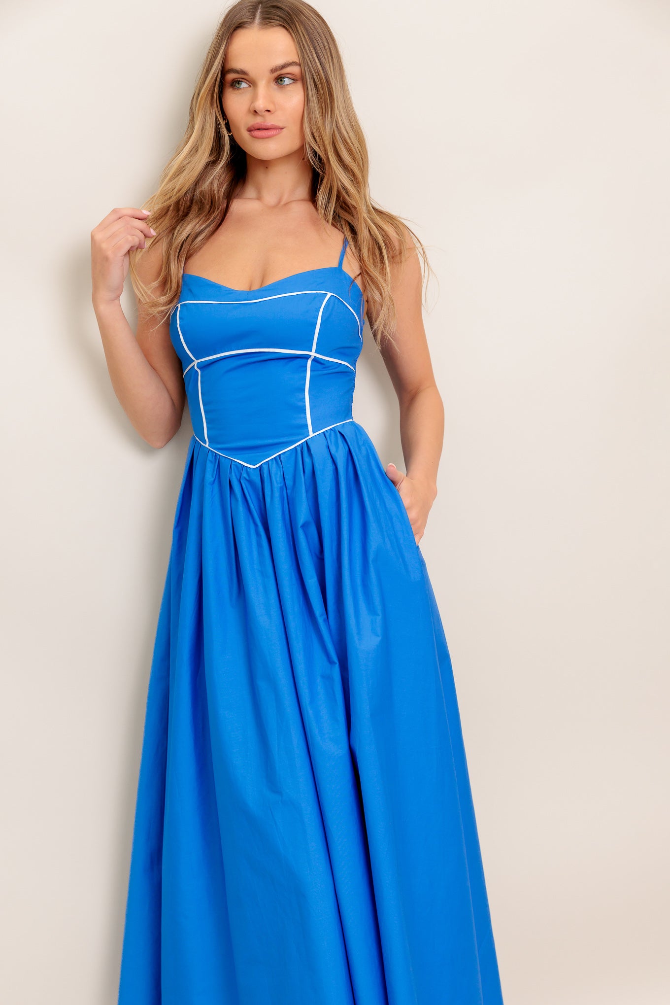 A solid woven midi dress featuring sweetheart neckline, straps, basque waist, full skirt and smocked back bodice