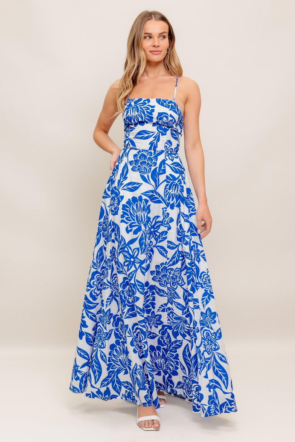 A printed woven ankle dress featuring straight neckline, circle skirt, bare back with cross straps
