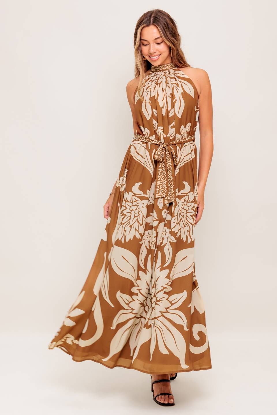 A printed woven ankle dress featuring halter neckline, self sash tie and back neck button closure