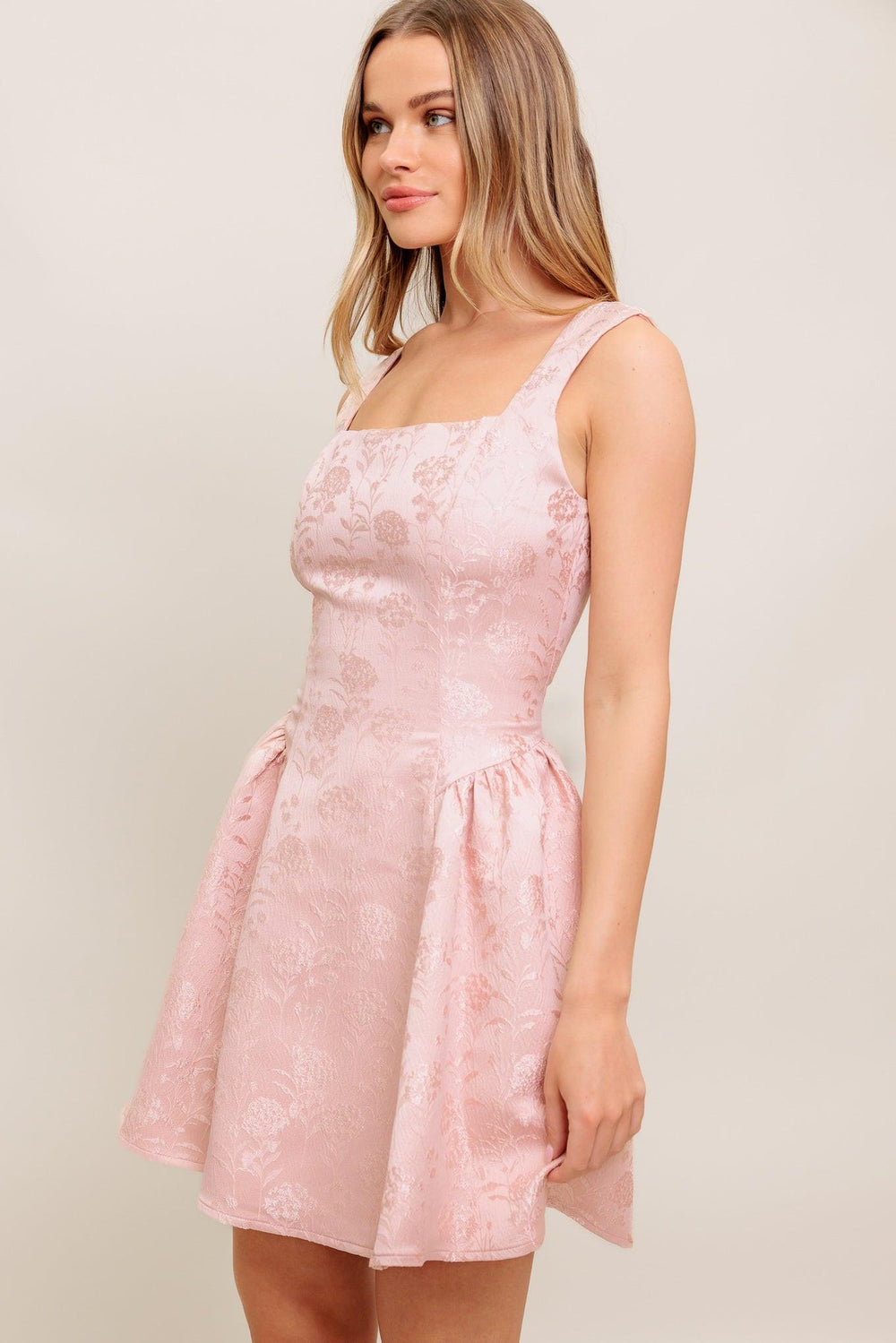 A woven jacquard satin mini dress featuring square neckline, sleeveless, side shirring and back zipper closure