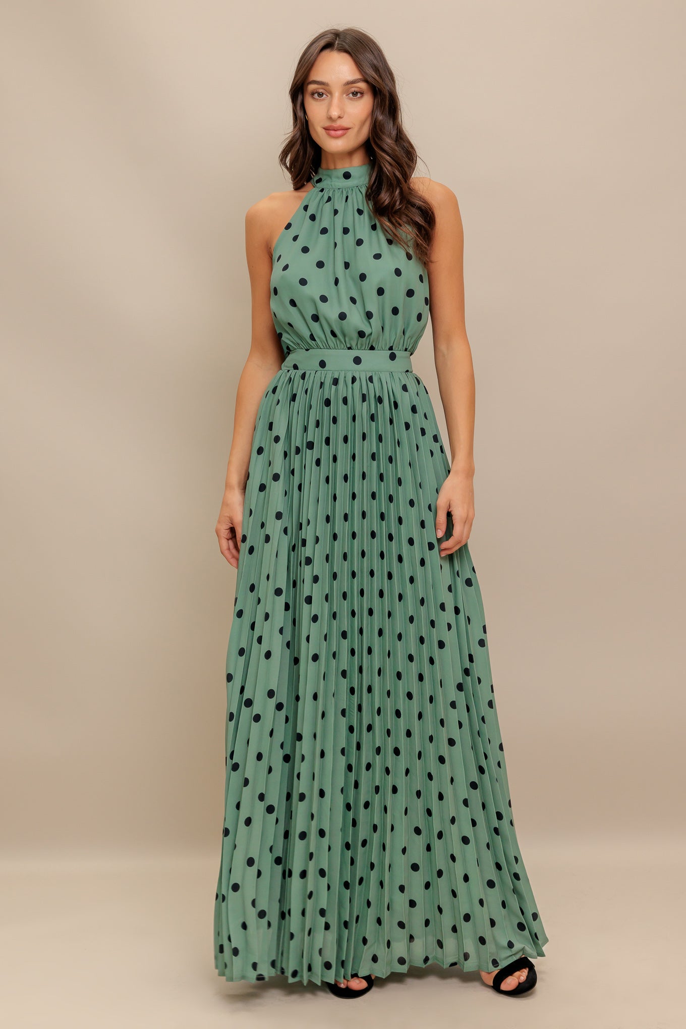 A printed woven maxi dress featuring halter neckline with back bow tie, sleeveless, pleated skirt and elasticized back waistband