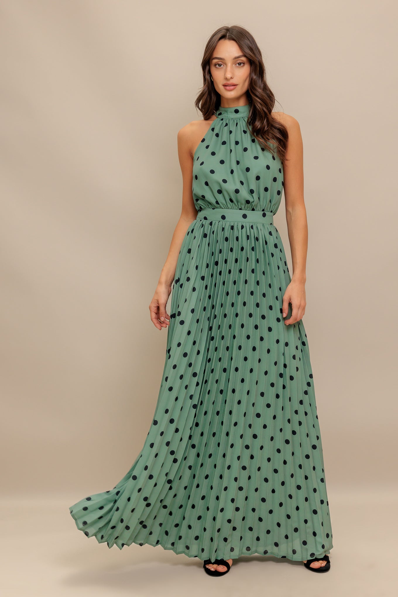 A printed woven maxi dress featuring halter neckline with back bow tie, sleeveless, pleated skirt and elasticized back waistband
