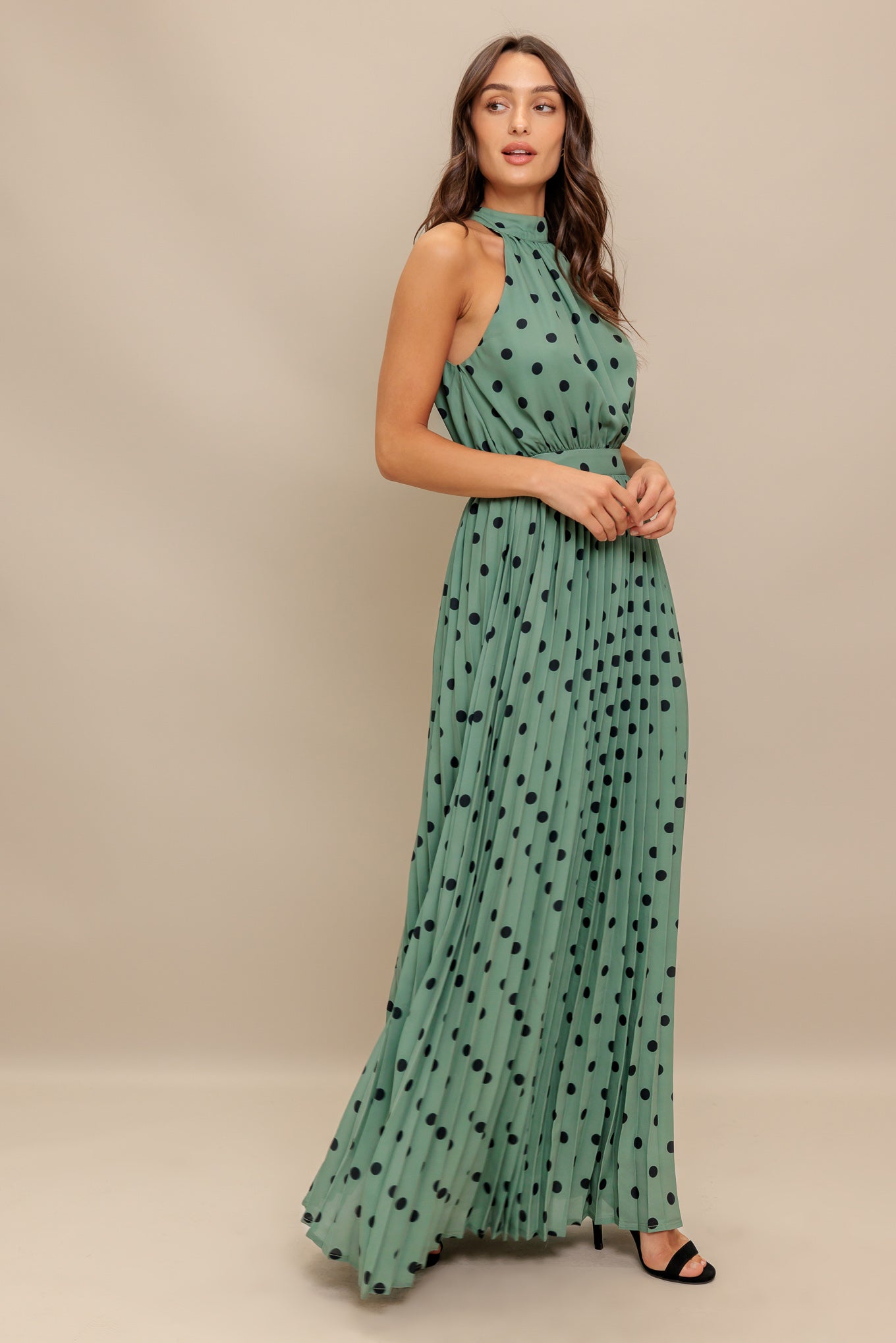 A printed woven maxi dress featuring halter neckline with back bow tie, sleeveless, pleated skirt and elasticized back waistband