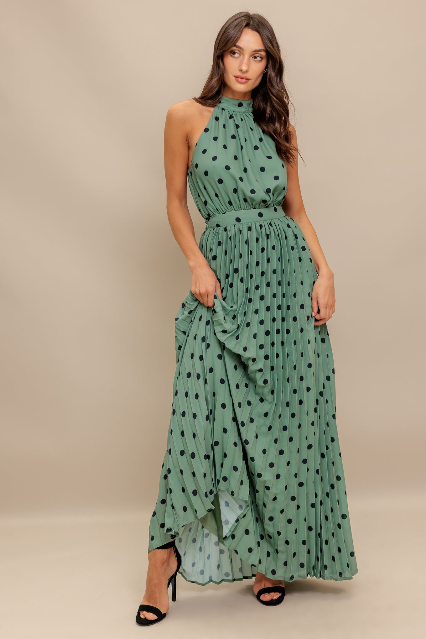 A printed woven maxi dress featuring halter neckline with back bow tie, sleeveless, pleated skirt and elasticized back waistband