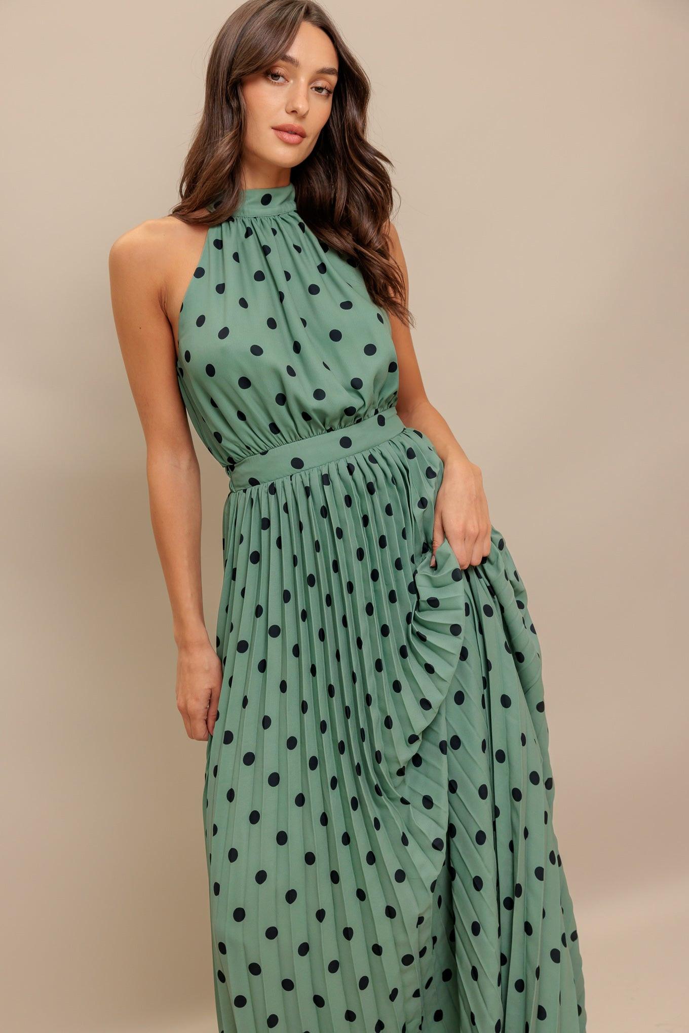 A printed woven maxi dress featuring halter neckline with back bow tie, sleeveless, pleated skirt and elasticized back waistband