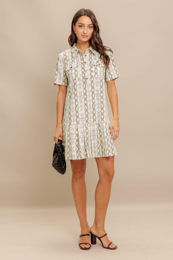 A printed woven mini dress featuring collar, short sleeve, pocket, button down and pleated bottom