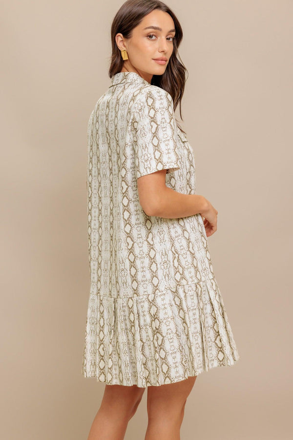 A printed woven mini dress featuring collar, short sleeve, pocket, button down and pleated bottom