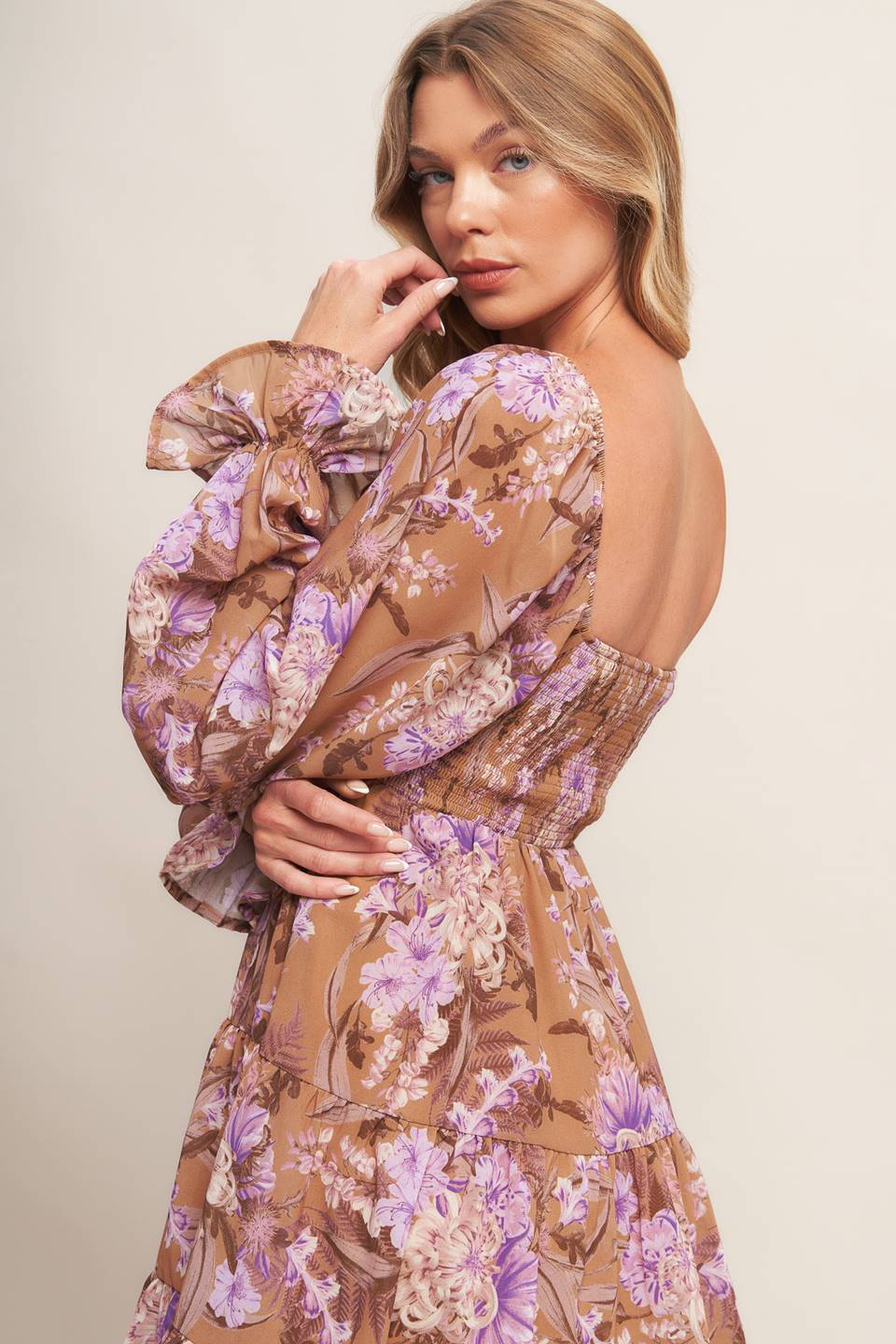 A printed woven mini dress featuring sweetheart neckline, smocked bodice, long sleeve with ruffled cuff and tiered skirt