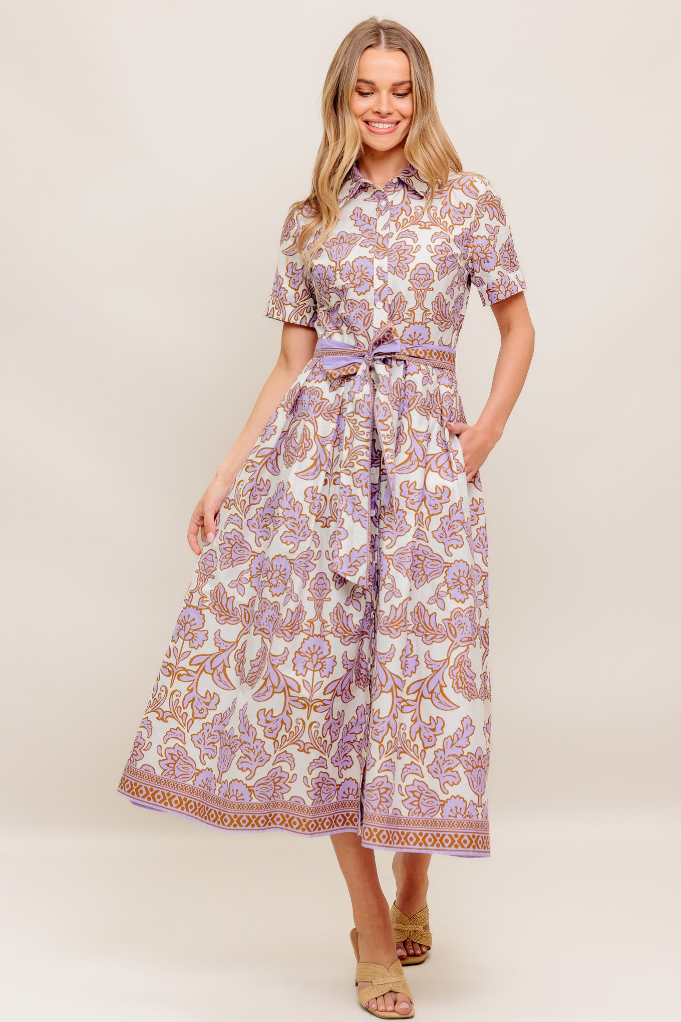 A printed woven mini dress featuring collar, short sleeve, button down, self sash tie and full skirt