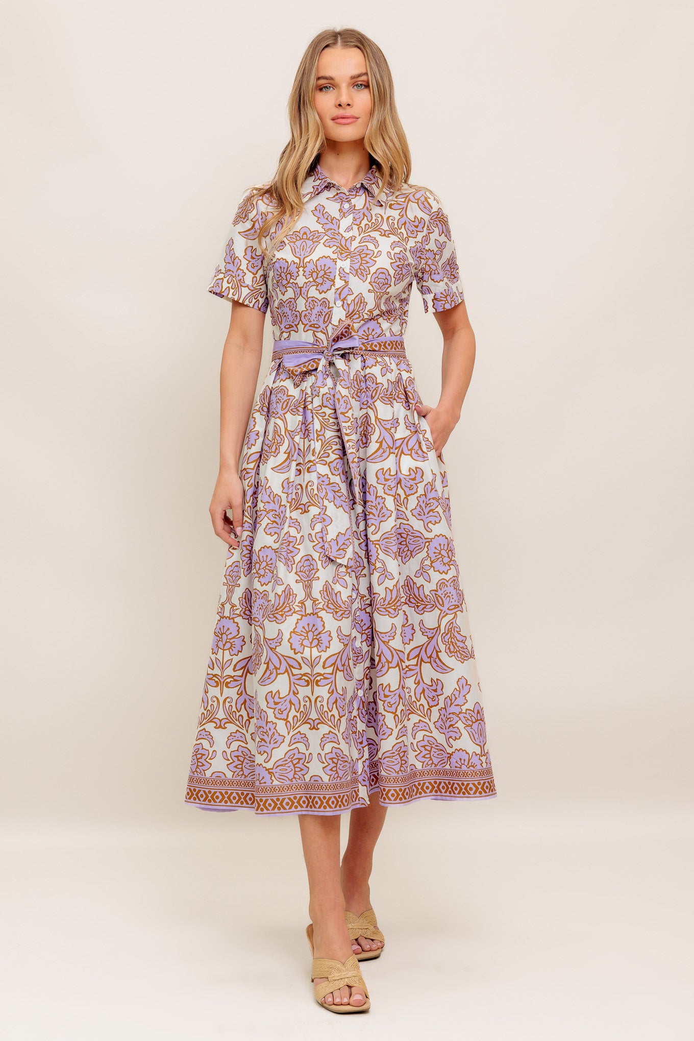 A printed woven mini dress featuring collar, short sleeve, button down, self sash tie and full skirt