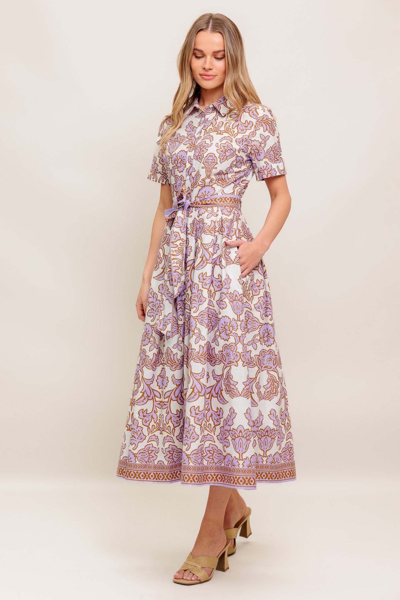 A printed woven mini dress featuring collar, short sleeve, button down, self sash tie and full skirt