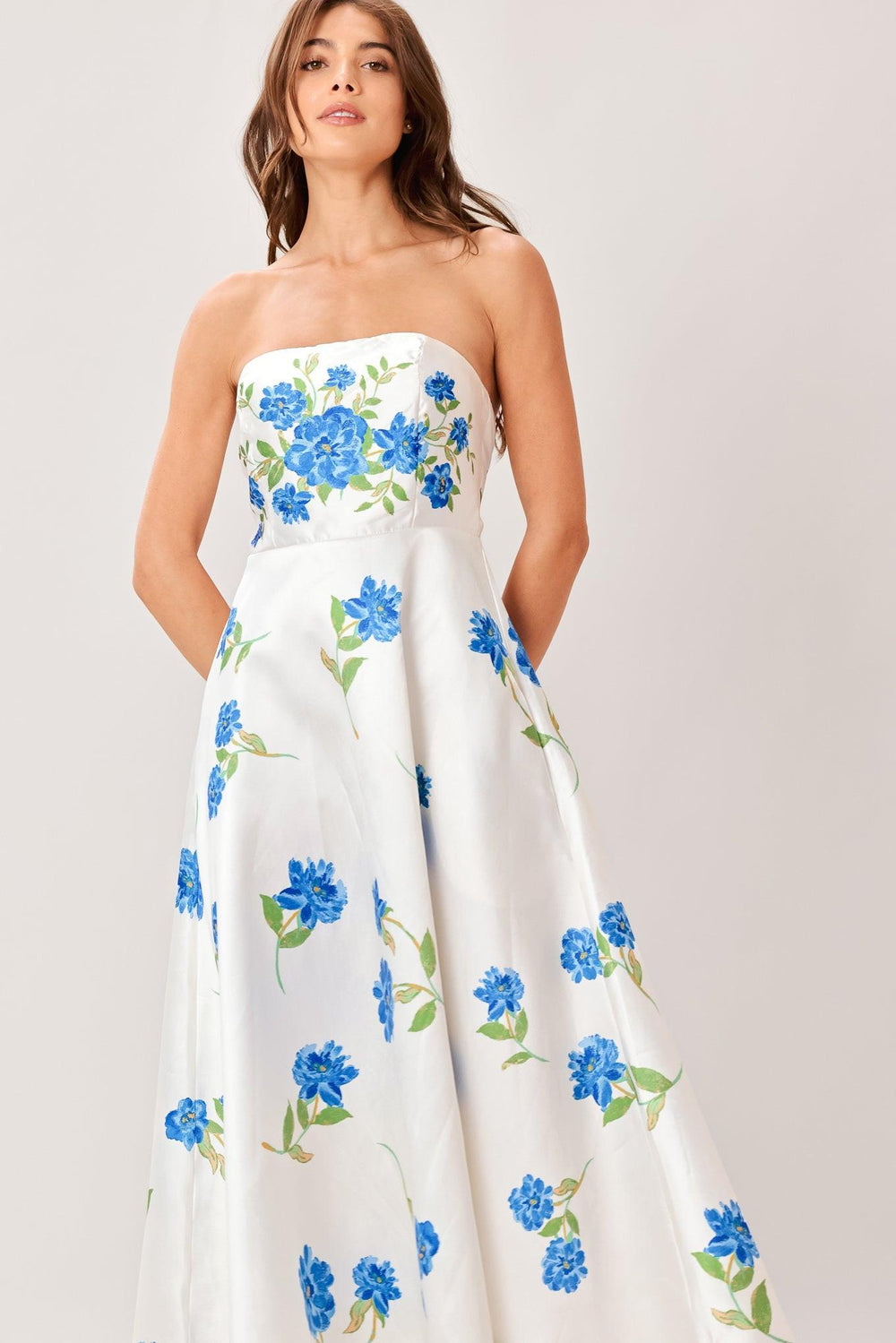 Woman wearing a strapless floral printed woven midi dress featuring strapless, circle skirt and back zipper closure 