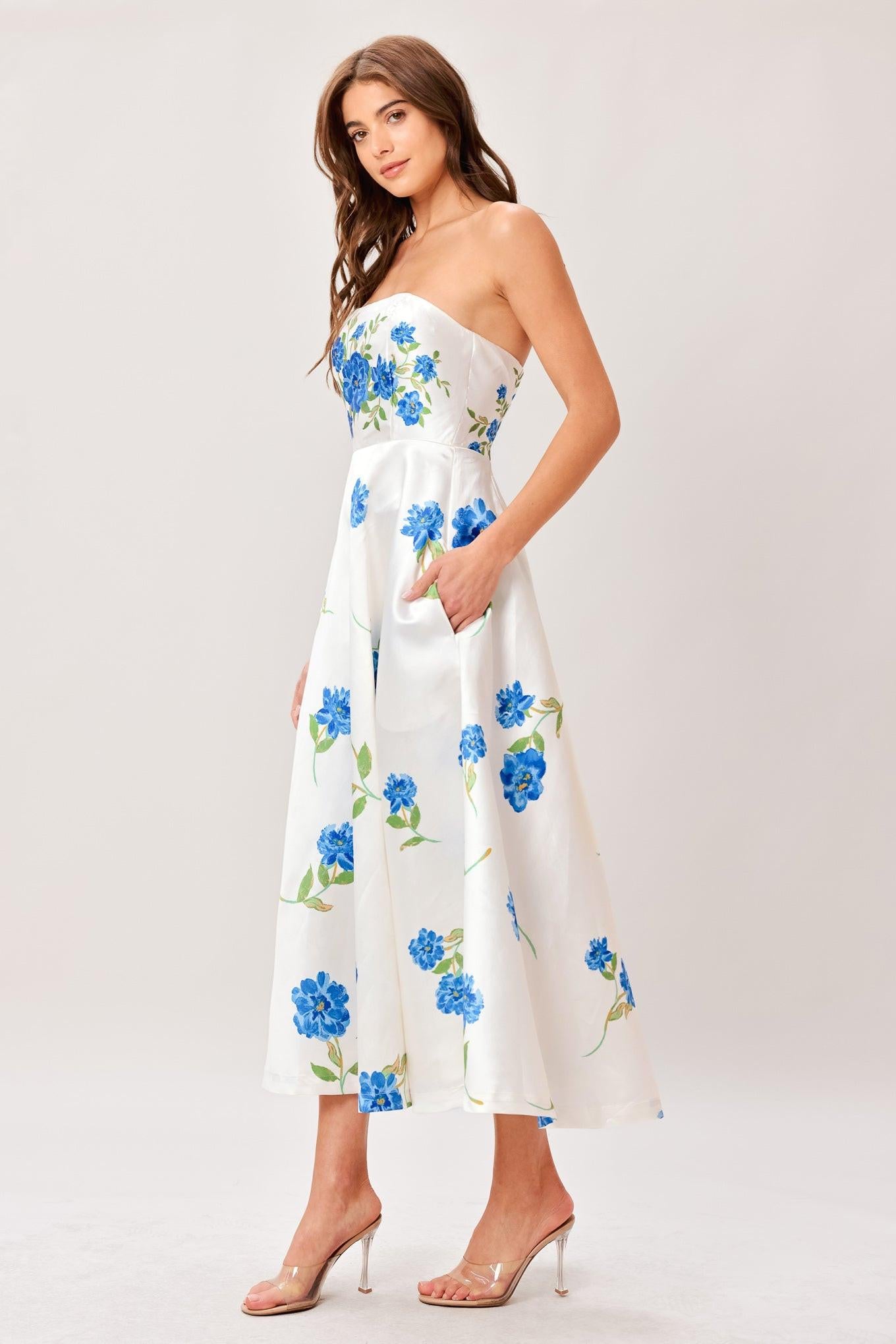 Woman wearing a strapless floral printed woven midi dress featuring strapless, circle skirt and back zipper closure 