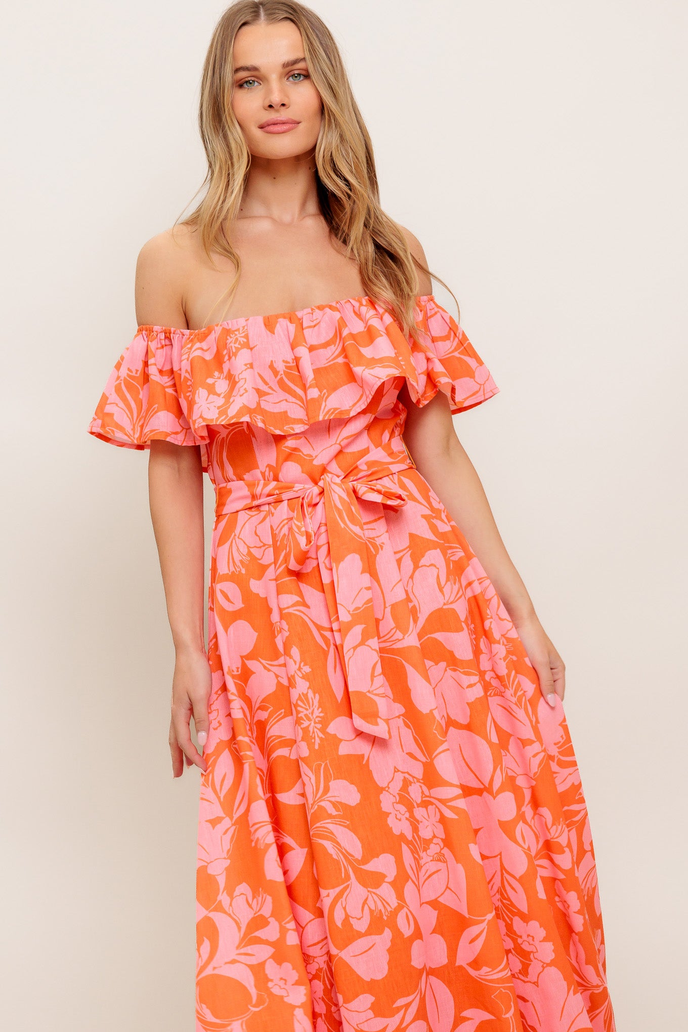 A printed woven midi dress featuring off shoulder neckline with flounce, self sash tie, circle skirt and back zipper closure