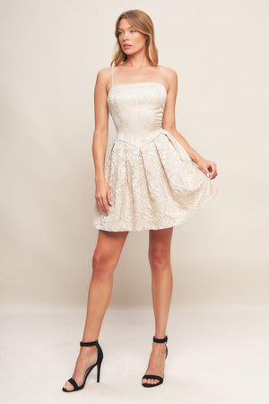 A textured woven mini dress featuring straight neckline, straps, basque waist, full skirt and back zipper closure