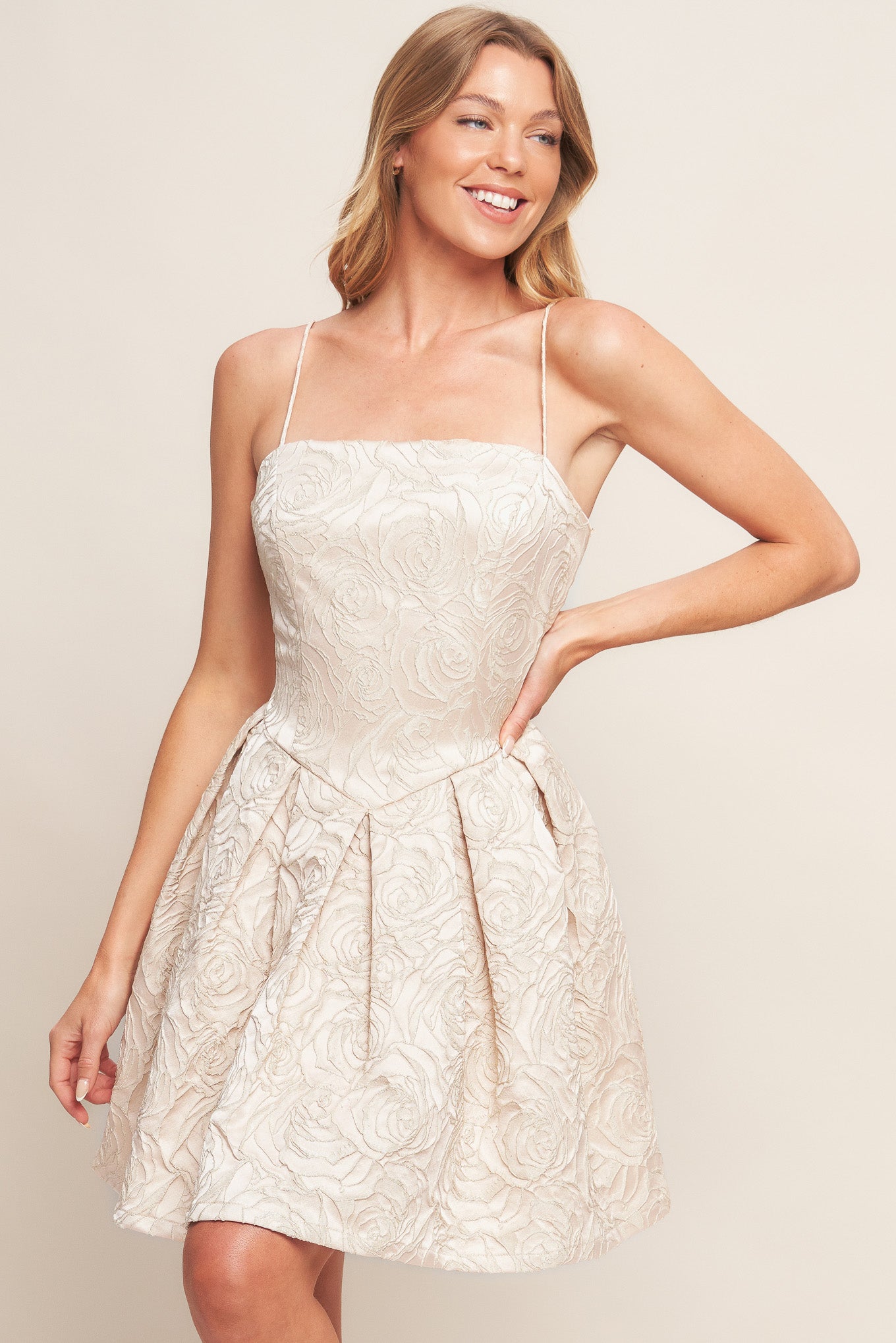 A textured woven mini dress featuring straight neckline, straps, basque waist, full skirt and back zipper closure