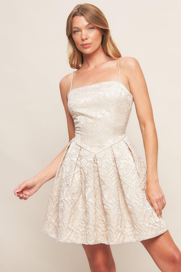 A textured woven mini dress featuring straight neckline, straps, basque waist, full skirt and back zipper closure