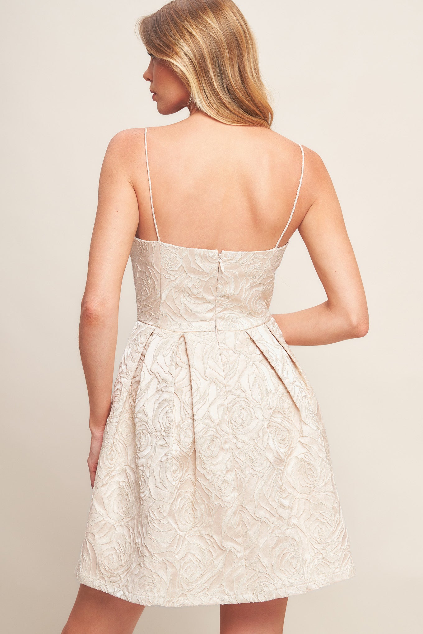 A textured woven mini dress featuring straight neckline, straps, basque waist, full skirt and back zipper closure