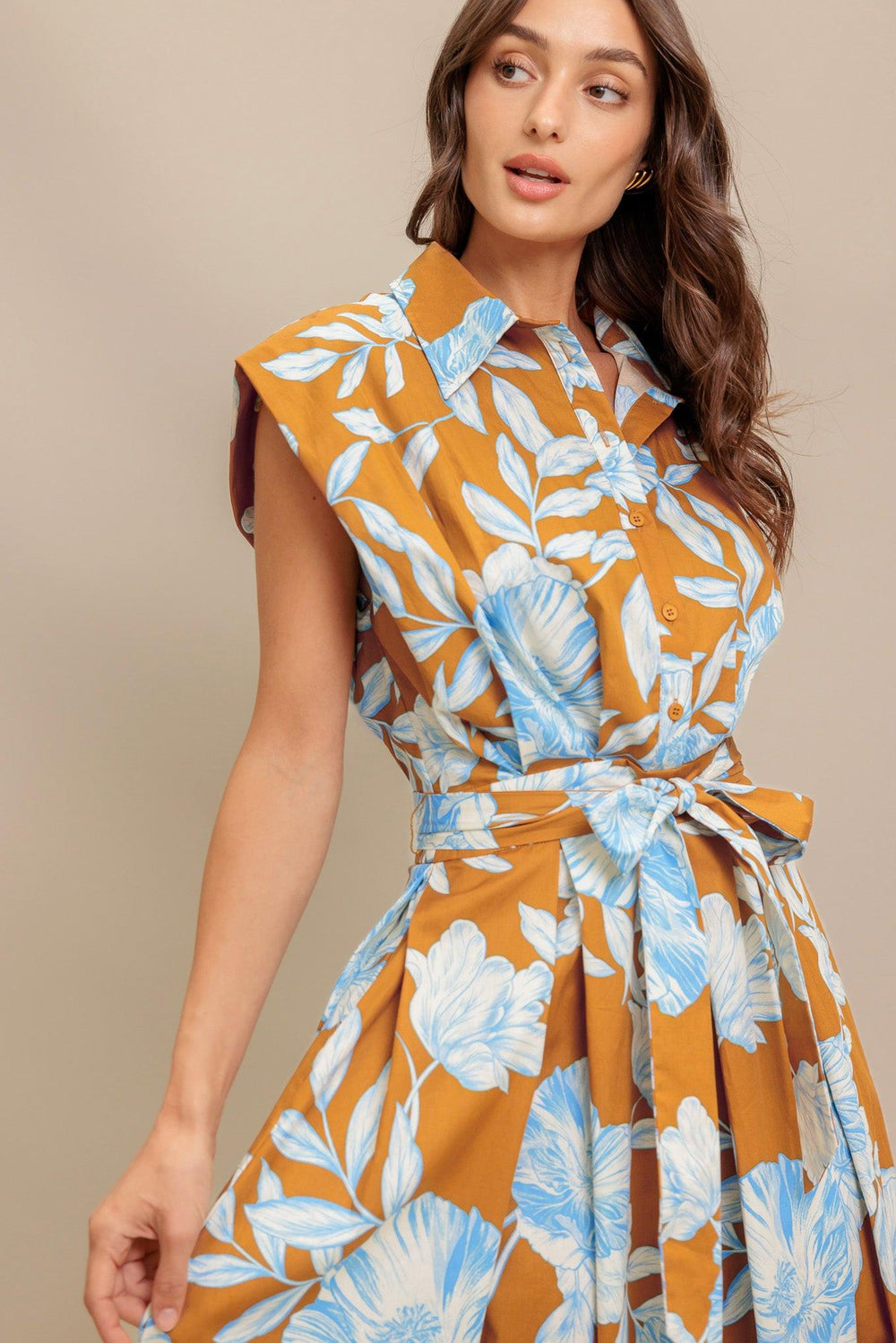 A printed woven midi dress featuring collar, short sleeve, front button down, self sash tie and full skirt